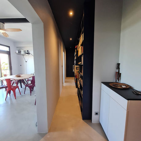 Couloir avec bibliothèque intégrée bleu profond et portes assorties – projet rénovation appartement 974