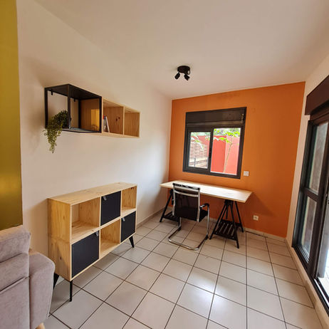 Bureau mural avec rangements bois et mur terracotta dans un appartement destiné à la location à La Réunion, projet d’aménagement par architecte d’intérieur 974.