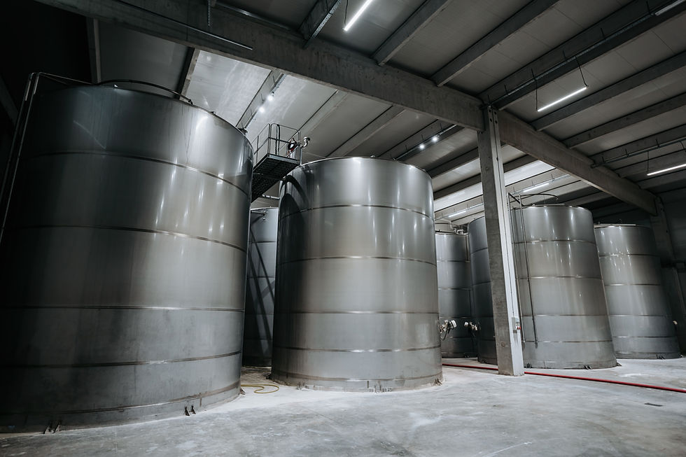 Huge warehouse for wine storing with giant stainless steel tanks. Industrial production of