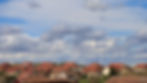 houses-foreground-wind-farm-background-red-roofs-cloudy-sky.jpg