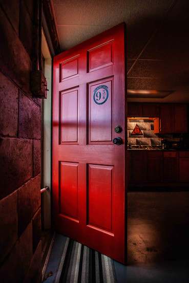 hogwarts-themed airbnb red door with platform 9 3/4 sticker opens into the living space