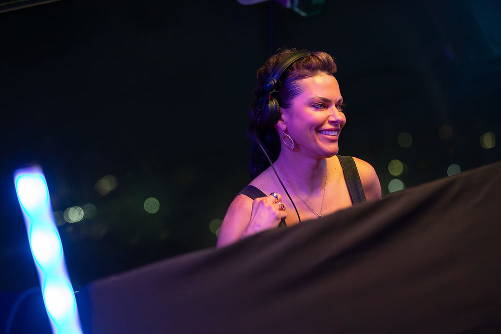 Smiling woman DJ with headphones performing live house music dj sets