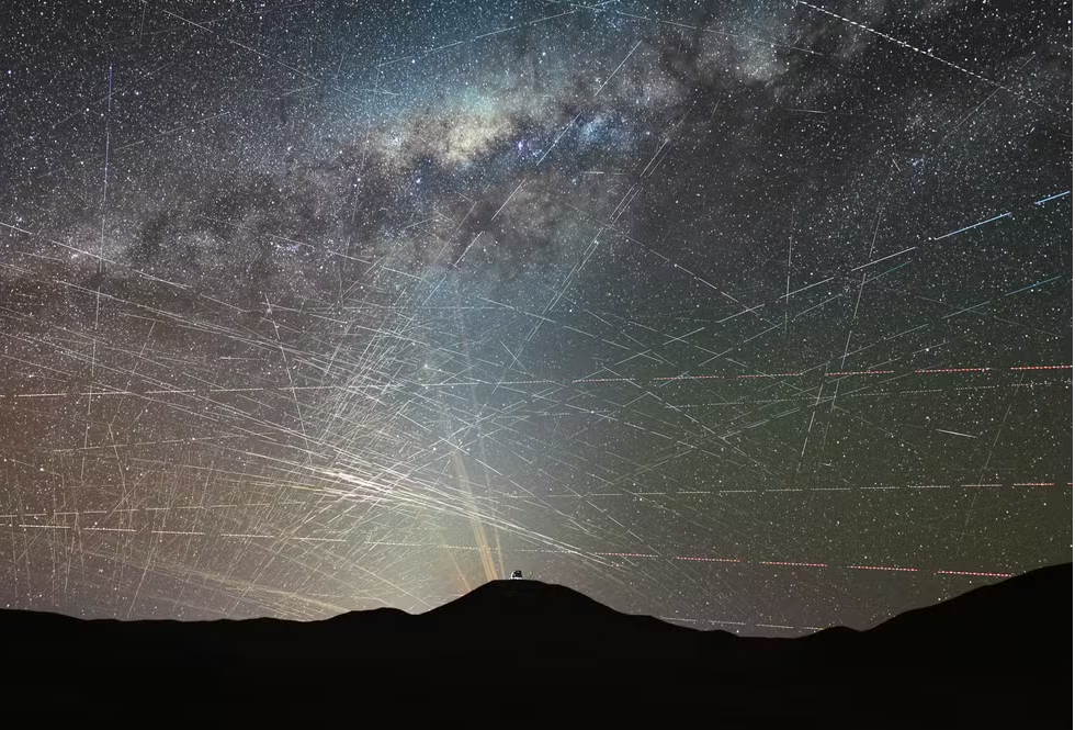 Rastros de satélites cruzam o céu sobre o deserto do Atacama, no Chile, durante registro de uma hora. Ao fundo, aparecem o ELT, em construção, e os lasers do VLT. Foto: F. Kamphues/ESO/M. Kornmesse