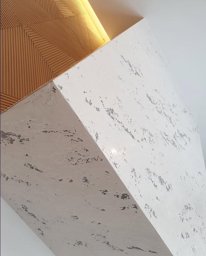White marble-look Venetian plaster wall panel with trim detail