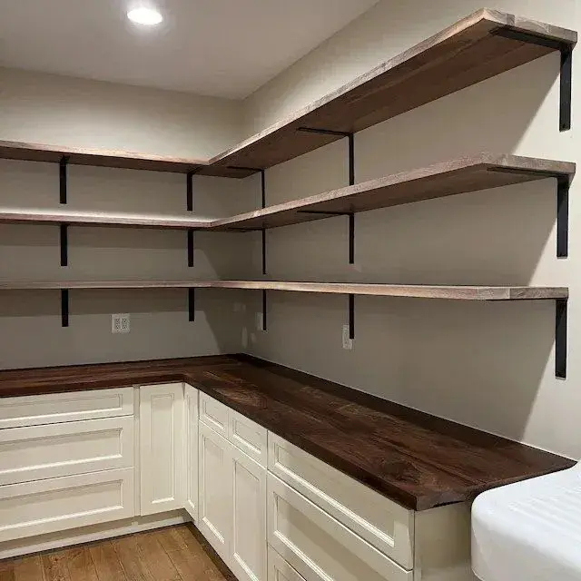 Wooden shelves and dark countertop in a corner kitchen with white cabinets. Neutral walls and wooden flooring create a warm atmosphere. contractor Clark County WA