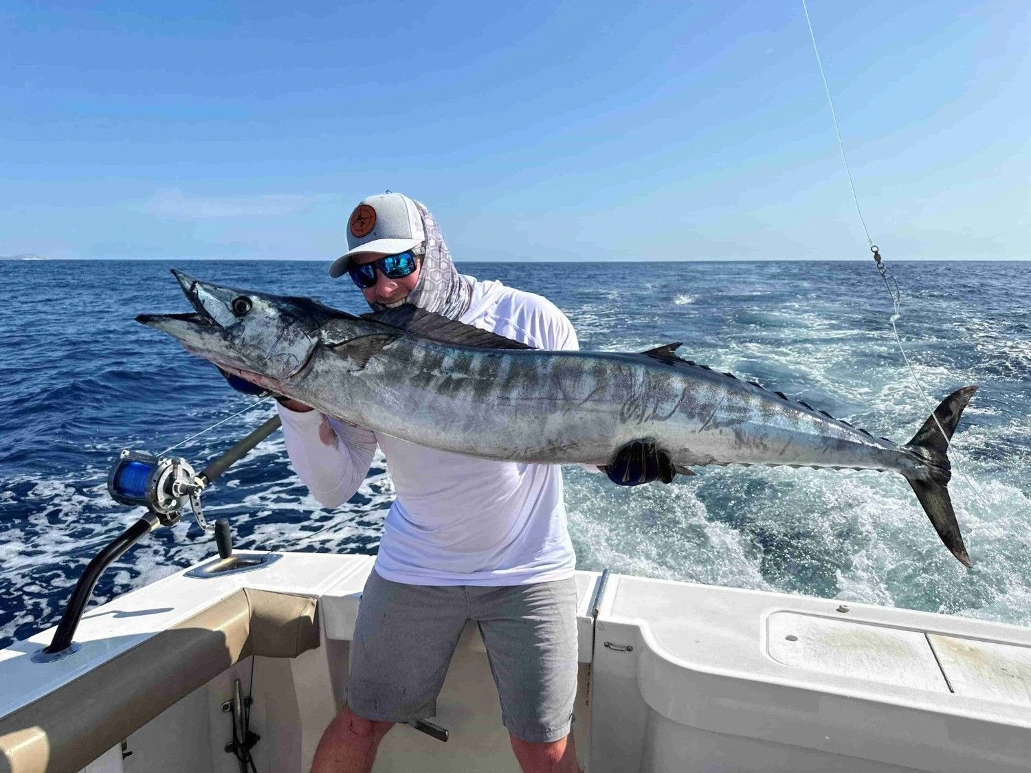Top Anglers Sportfishing guest holds a large wahoo caught during their fishing charter in Cabo