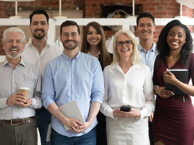 Happy-diverse-professional-business-team-stand-in-office-looking-at-camera-smiling-young-a