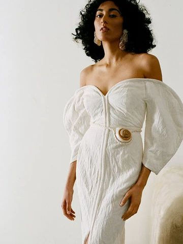 model wearing white scultural dress with puffy off shoulder sleeves