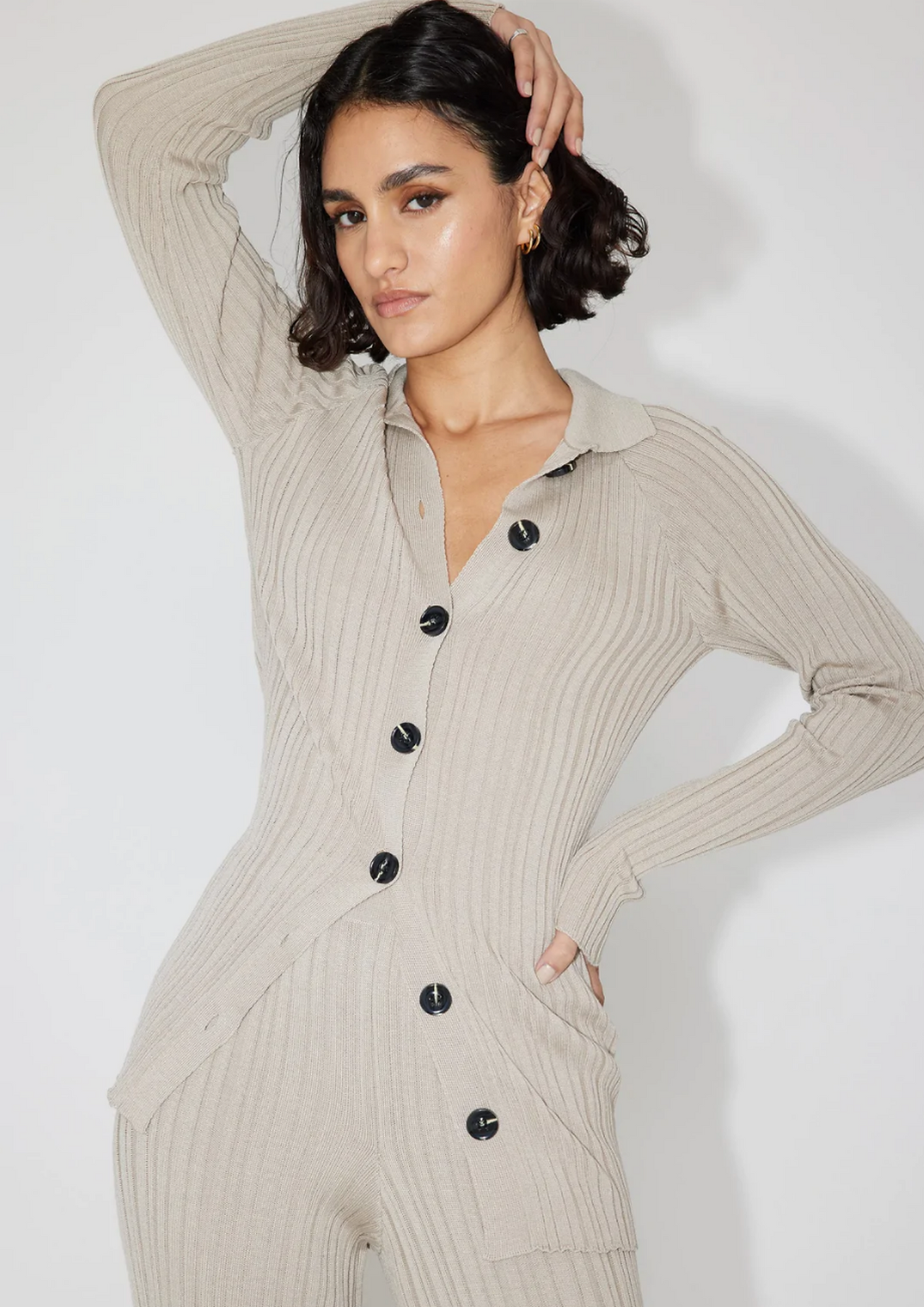 model wearing al beige woolen set of rib pants and buttondown wool cardigan