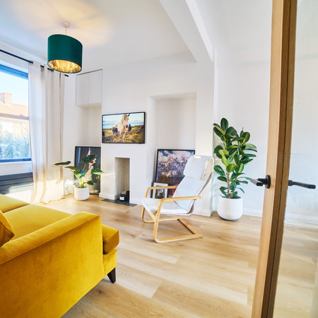 Modern living room with natural light and yellow armchair