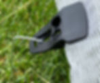 Tarp clip attached to netting with landscape staple securing it to the ground
