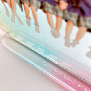 SPRING POPシリーズの台座に刻まれた “let's become wonderful friends” の文字と虹色グラデーションの背景(拡大)
