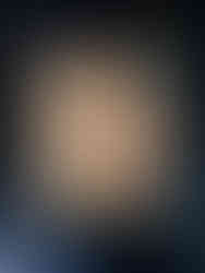 Raw chicken breast in a glass container sitting on a black and white marble countertop