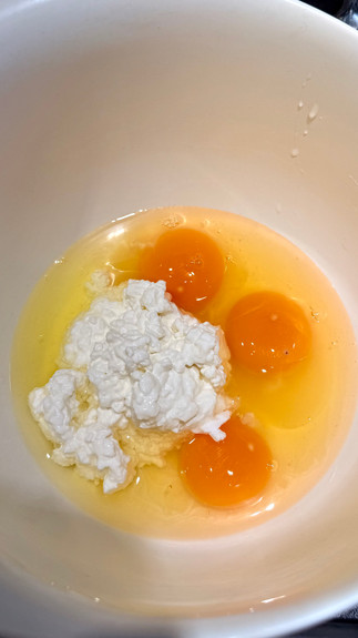 Egg yolks and cottage cheese inside a white bowl