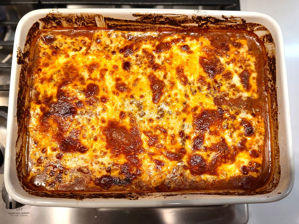 Golden-brown baked chicken with melted cheese in a white dish, fresh from the oven on a metallic stovetop, creating a warm, appetizing feel.