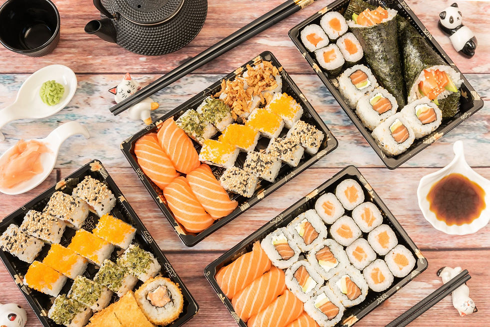 Mesa posta com peças de comida japonesa e outros itens da culinária oriental.