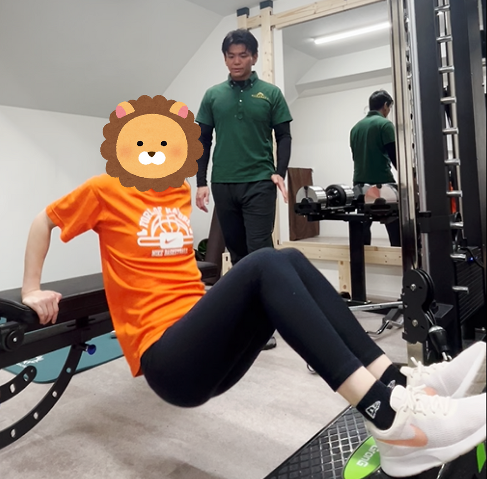 パーソナルジムでベンチを使った上腕のトレーニングを行う女性と、それを指導するトレーナー