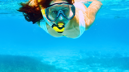 Snorkeler exploring vibrant coral reefs in the clear waters around Little Corn Island.