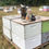 Thumbnail: a bee smoker and an embroidered richardson brand hat sitting on top of a pallet of bee boxes
