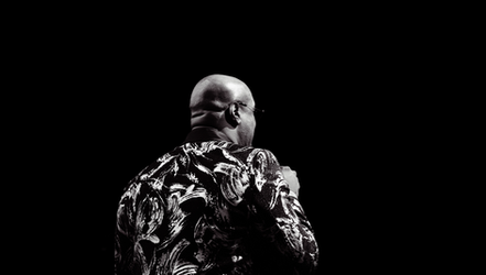 a bald man wearing glasses and a black and white shirt