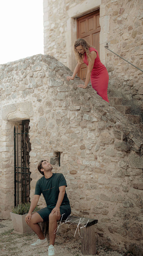 Pareja caminando a lo largo de un muro histórico al aire libre
