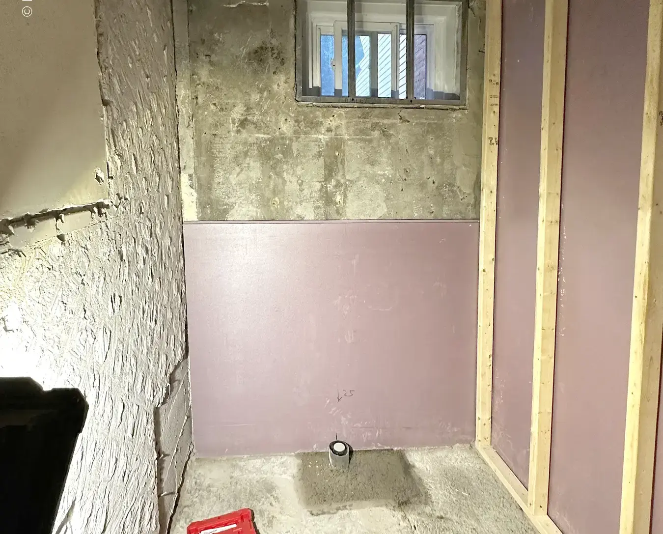 Basement bathroom rough-in framing with insulation, concrete floor