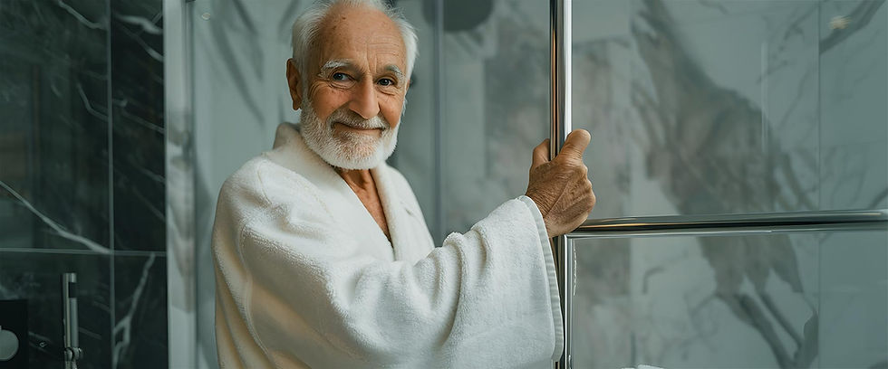 Old man holding onto a grab bar for safety in a nice shower area.