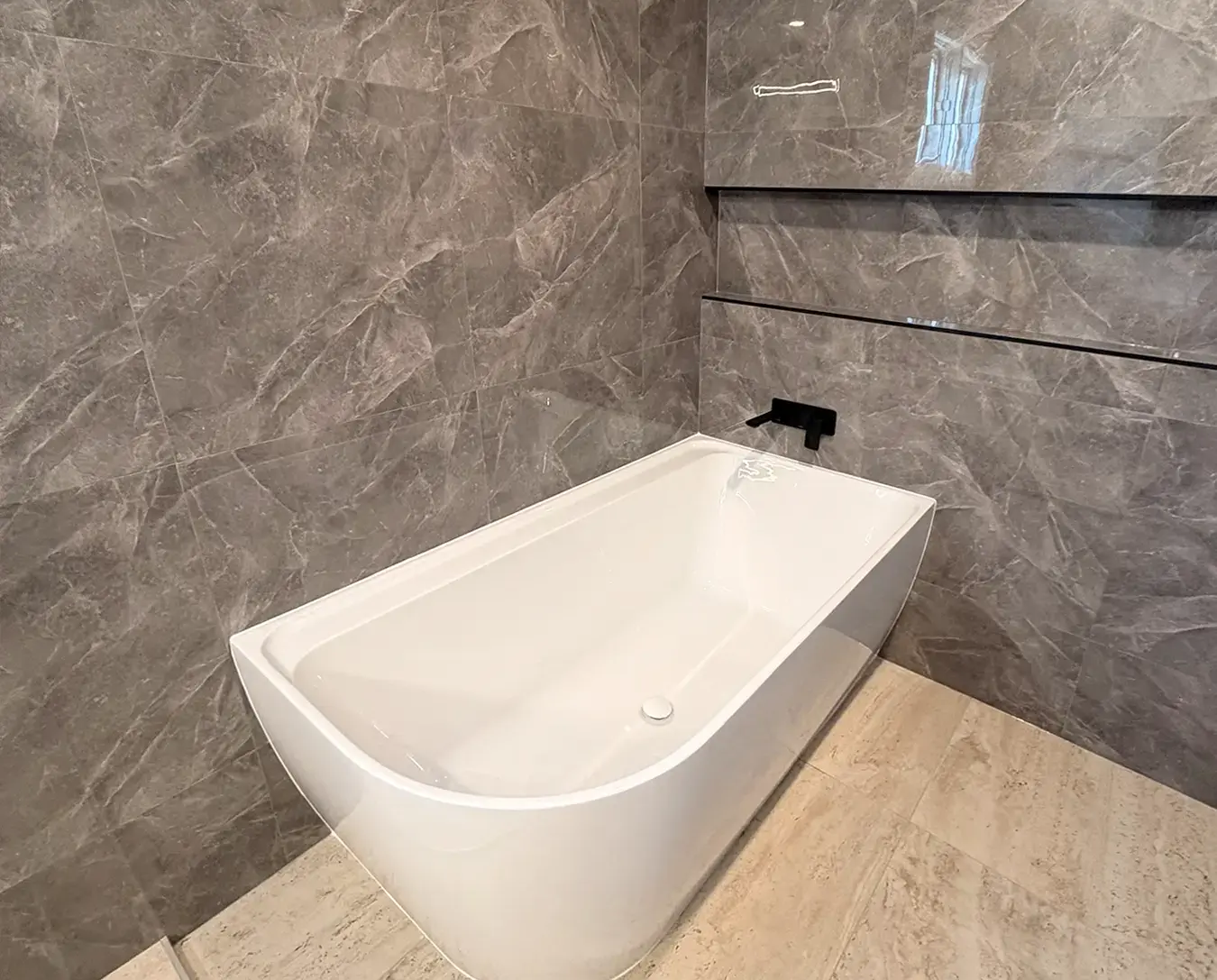 White soaking tub paired with black fixtures.