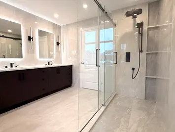Double vanity bathroom with glass shower.