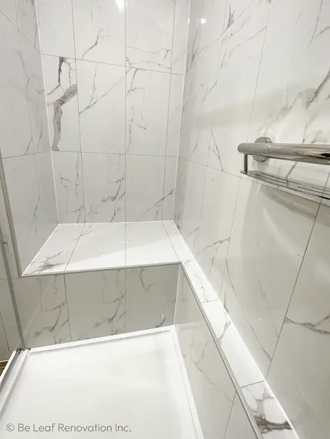 Custom tiled walk-in shower enclosure with built-in corner bench and marble pattern tiles