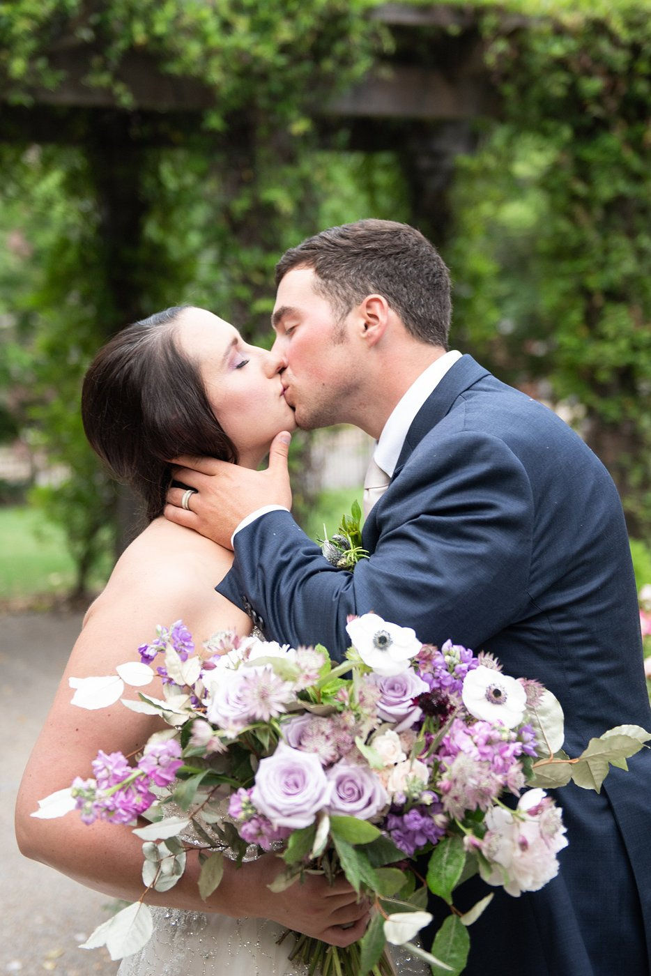 Groom cradling bride's face for a kiss