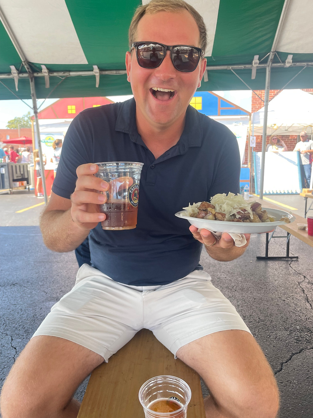 Man drinking beer and eating food at a German food festival