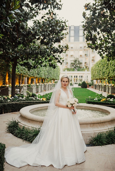 Bride portrait at Ritz Paris wedding in garden courtyard with fountain and elegant dress