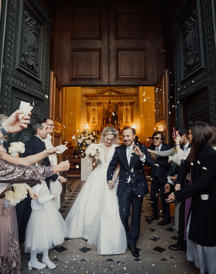 Bride and groom exit church during Ritz Paris wedding with guests throwing petals