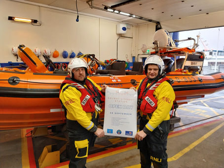 Galway RNLI volunteer crew with the open day poster