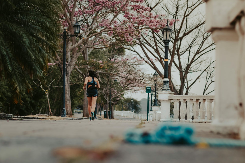 Female runner jogging down a tree-lined road