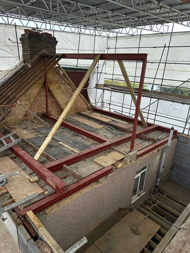 Scaffolding and steel beams in place on an old building ready for a new dormer roof to be built altering the building.
