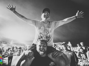 Kyle Loftis on top of shoulders raising his hands and smiling at Ice Cream Cruise