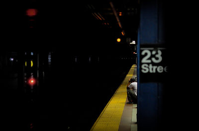Person squatting on subway station