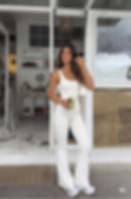 Modelo usando macacão fitness flare branco Mykonos SKYM em ambiente sofisticado