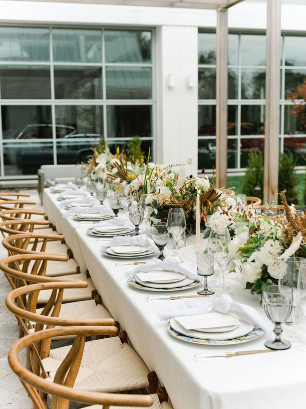 White banquet table with white florals at outdoor summer wedding 