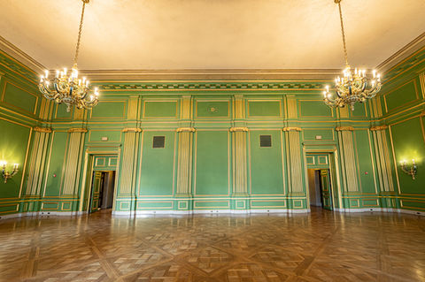 Luxurious Green Rooms at Andrew W. Mellon Auditorium with rich emerald walls with gold accents, chandelier lighting, and hardwood parquet floors, perfect for VIP lounge or cocktail receptions.