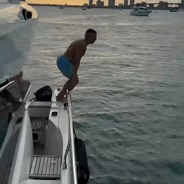 Theo Marcopoulos,  45+, can easily dive off a boat into the calm waters at sunset, with the silhouettes of the cityscape in the background.