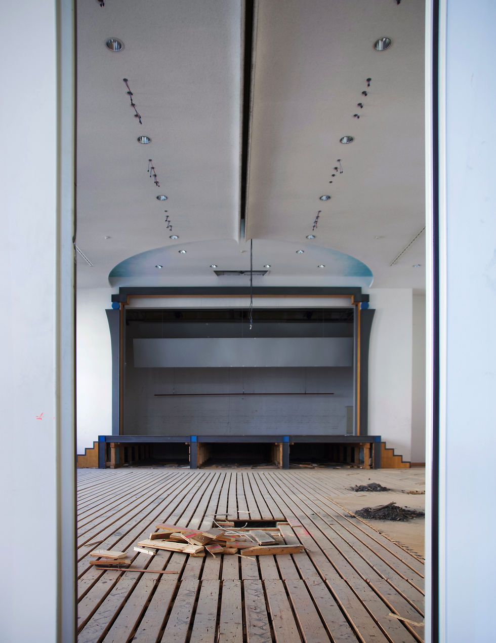 Zwischen sieben Meter hohen Schiebewänden, welche den Vorsaal vom Hauptsaal trennen, erblicke ich den grossen gloriosen Ekkehard Saal, in dessen Mitte eine symmetrische, blau akzentuierte Bühne liegt. Der Boden ist aufgerissen und das Parkett von den Dielen entfernt. Die hängende Deckenbeleuchtung wurde entfernt und es hängen stellvertretend nur noch Kabel von der Decke.