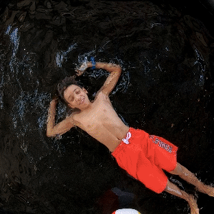 ExciA boy splashing water in a pool, showcasing the fun energy of our Splash Booth—by Funboxx Photo Booths.
