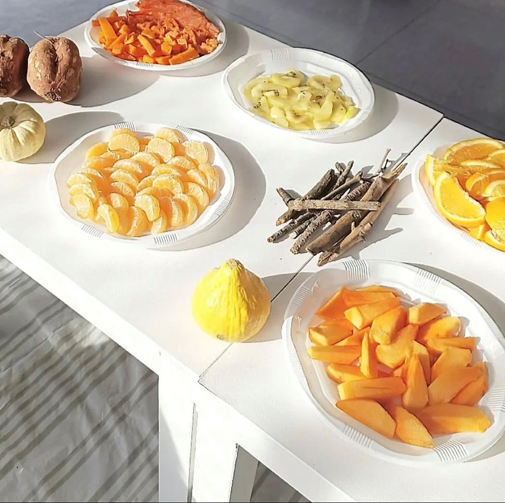 Taula amb fruites i elements naturals per a una activitat de tardor amb infants.