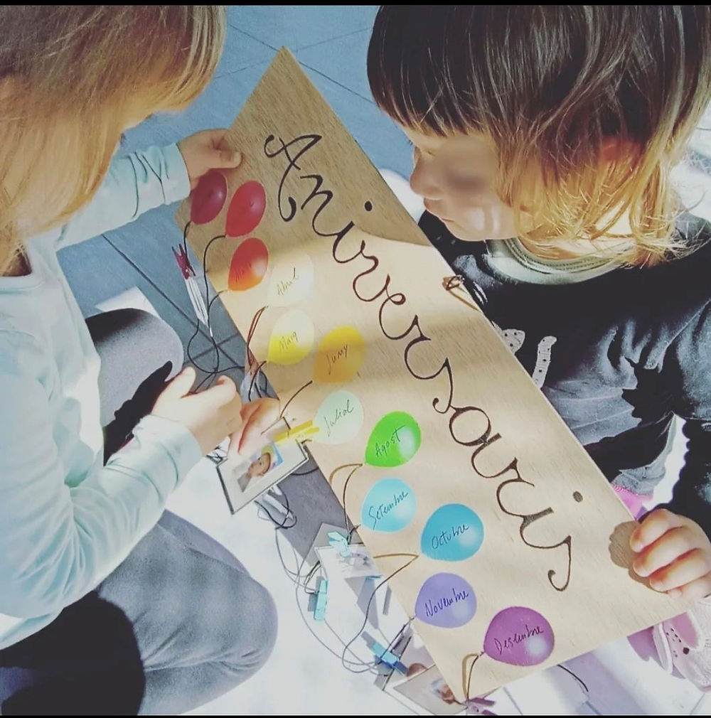 Infants observant un panell d’aniversaris en una activitat educativa a Passet a Passet.