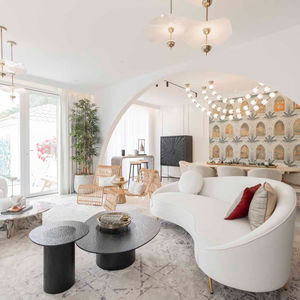 a living room with a curved couch and two coffee tables