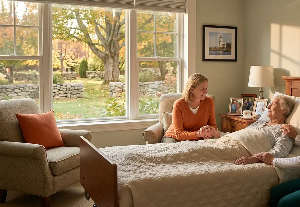 A warm, sunlit hospice room in Connecticut where a female caregiver and a family member sit bedside, holding the hands of an elderly woman resting comfortably. A large window shows a peaceful autumn garden with stone walls.