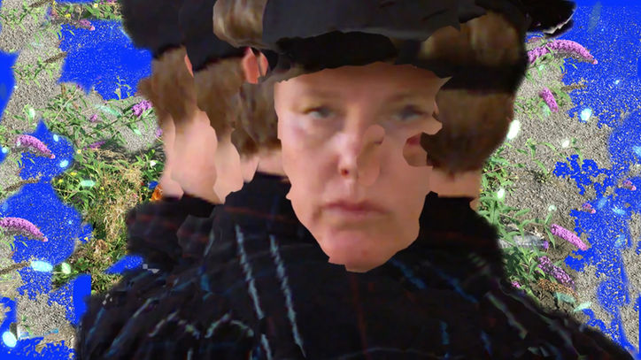 The face of AO Roberts, a white non-binary person, wearing a baseball cap and black shirt. The image is fragmented and made of many misaligned planes giving a feeling of disjuncture. 